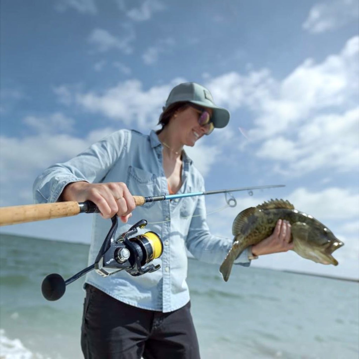 Woman holding a caught fish with a Shimano Spheros SW spinning reel and fishing rod, Dogfish Tackle & Marine