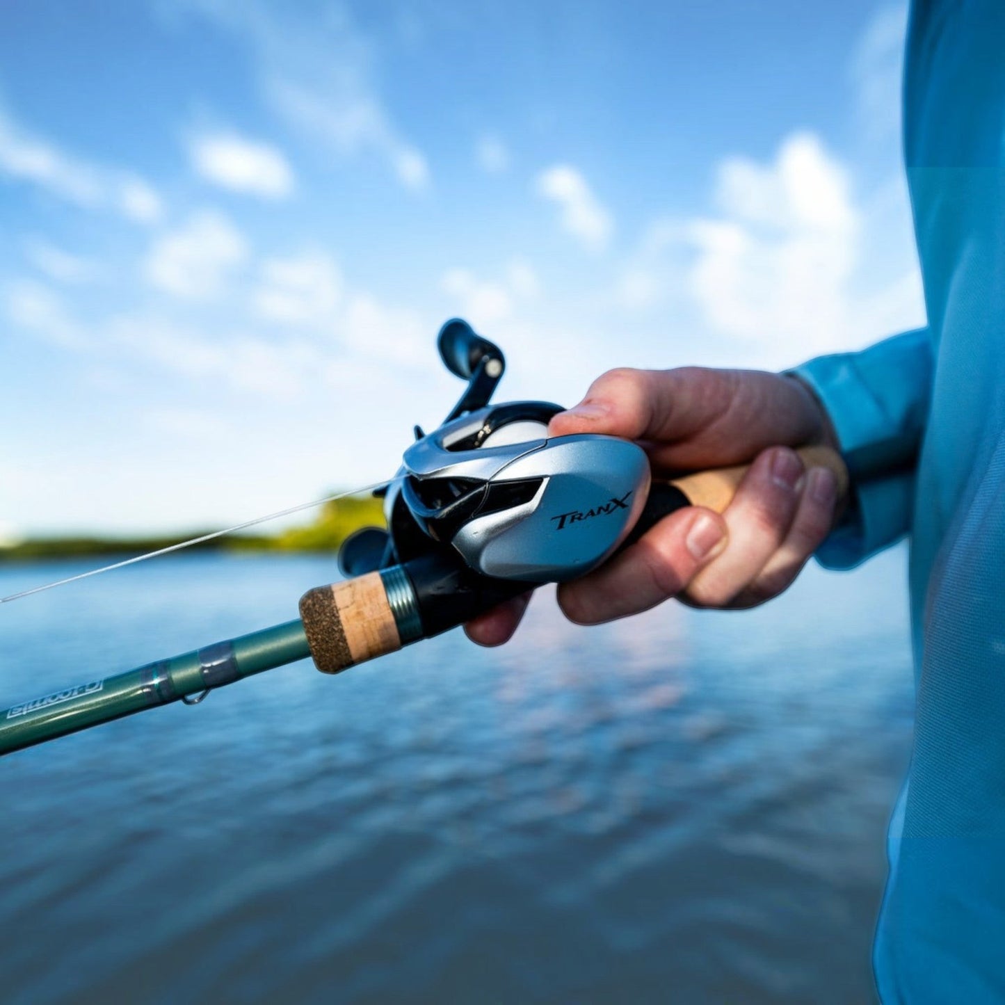 Dogfish Tackle & Marine Shimano Tranx 400 B baitcasting reel, silver and black, held by a person fishing.