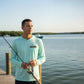 Man holding a fishing rod on a dock by a body of water