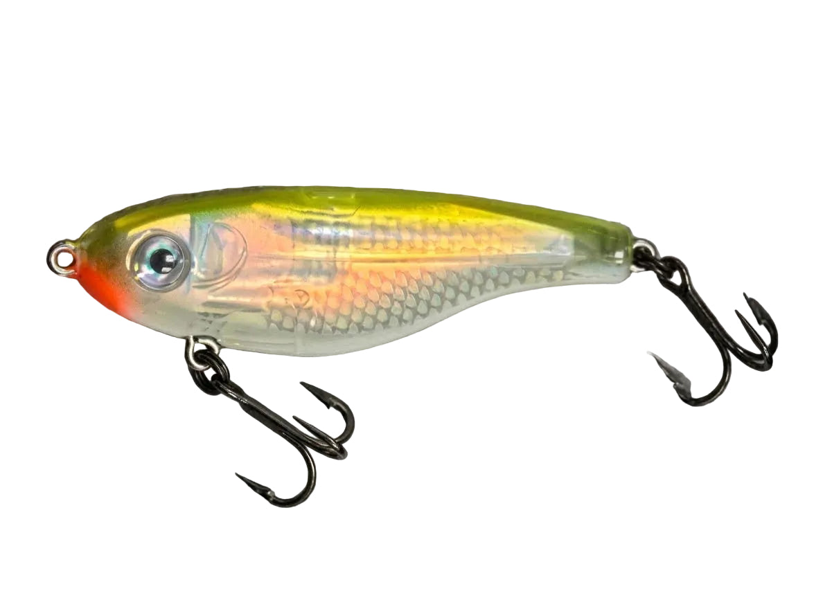 A hard fishing lure with a translucent body, yellow top, orange-red belly, and black treble hooks, shown on a textured gray background.