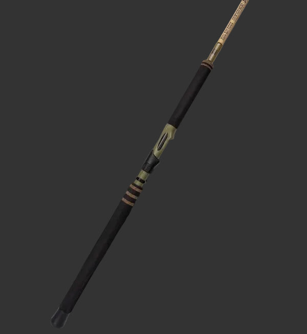 A premium fishing rod with a black handle and gold-colored metallic sections, shown diagonally against a dark, moody studio background.