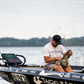 Angler on a Dogfish Tackle & Marine boat opening a camo 6th Sense Large Bait Bag to organize soft plastic lures.