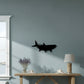Dogfish Tackle & Marine black metal fish wall art mounted on a light blue wall above a wooden console table.