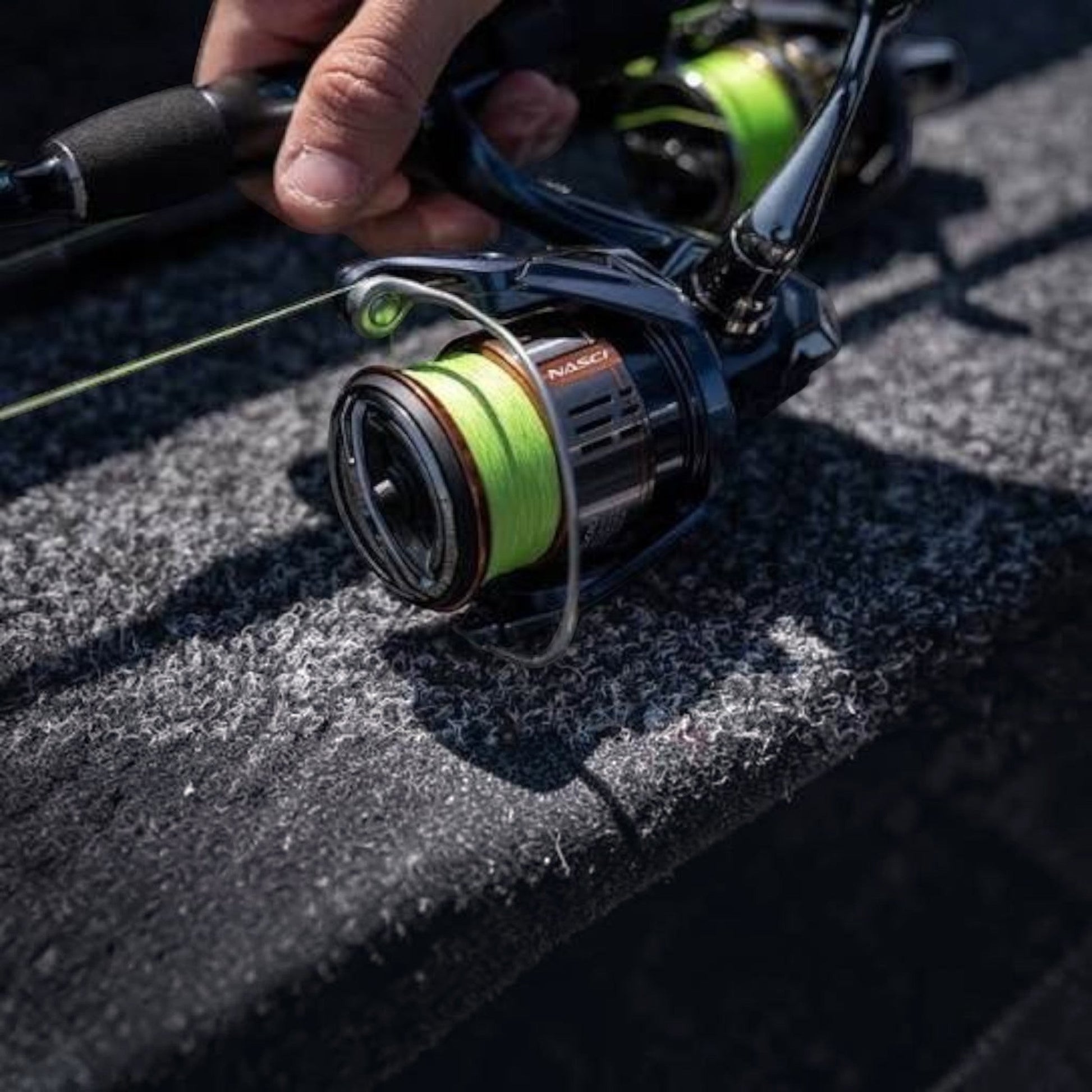 Dogfish Tackle & Marine Shimano Nasci FD spinning reel with neon green fishing line on a boat deck.
