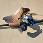 Dogfish Tackle & Marine Shimano Tranx 300HG baitcasting reel with cork handle and green fishing rod, next to a fish tail.