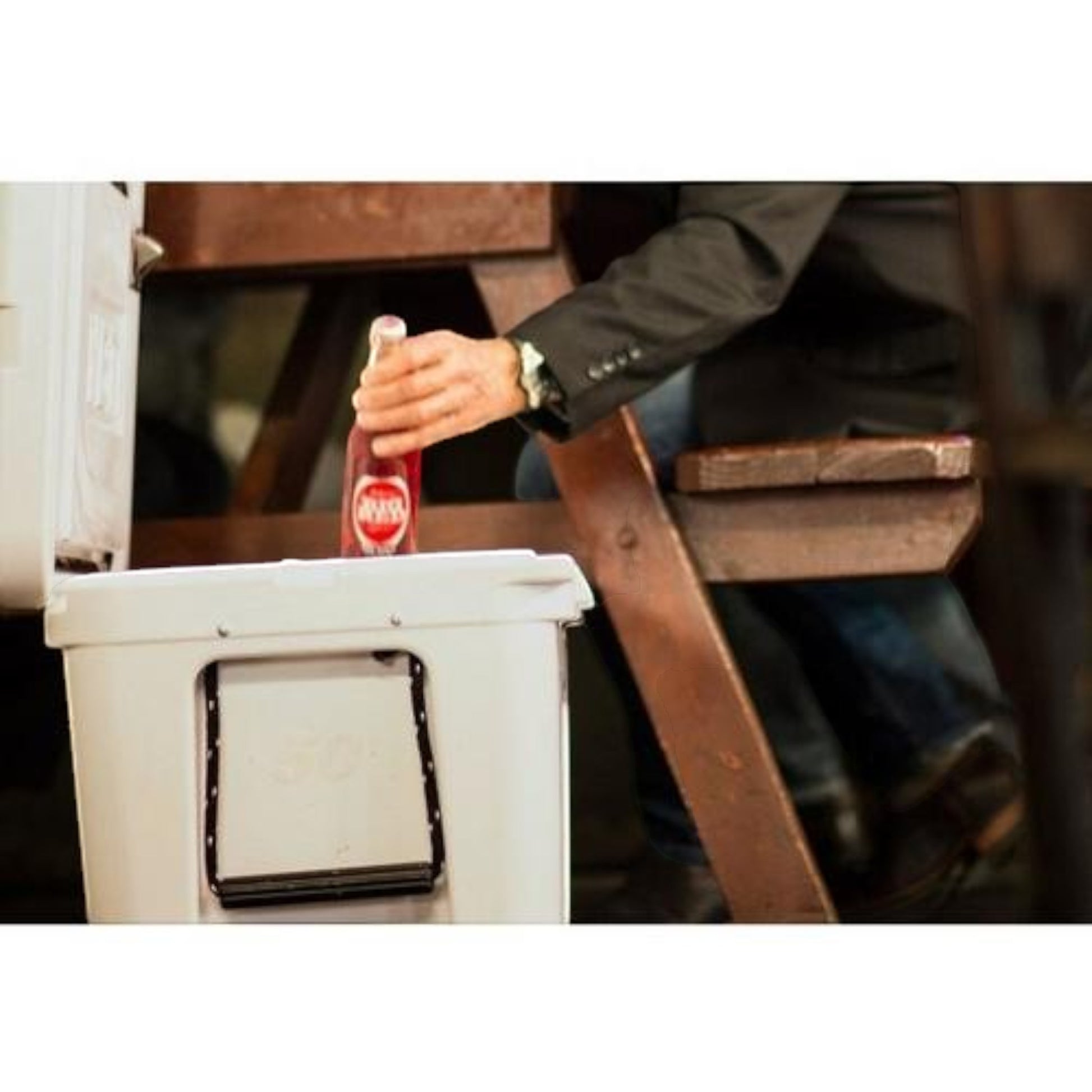 Dogfish Tackle & Marine white Yeti Tundra 50 hard cooler with a person reaching for a drink at a wooden table