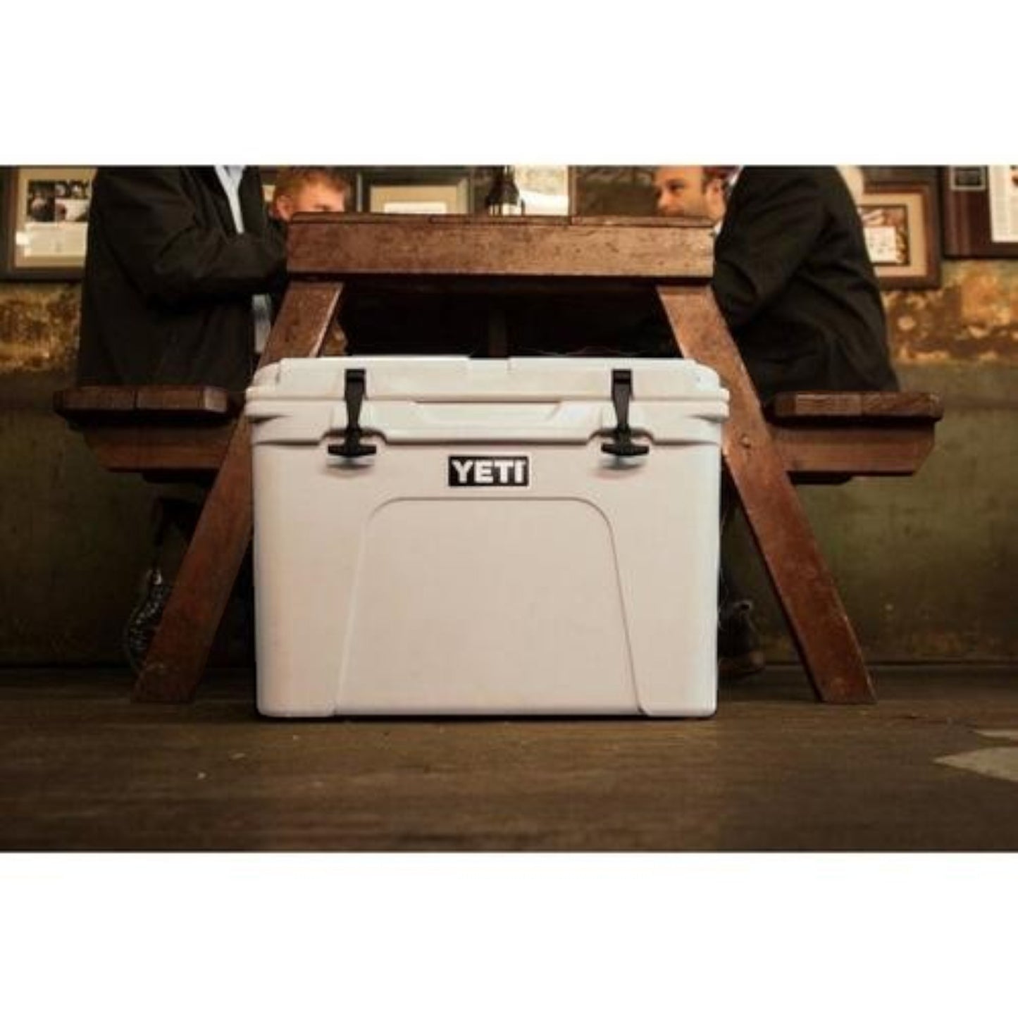Dogfish Tackle & Marine white Yeti Tundra 50 hard cooler with black latches sitting under a wooden picnic table