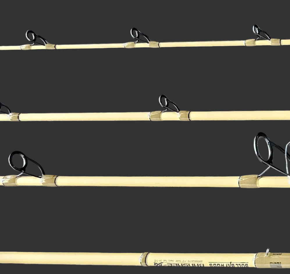 Three fishing rods with black line guides and metal reel seats laid out horizontally on a dark gray wood-grain surface.